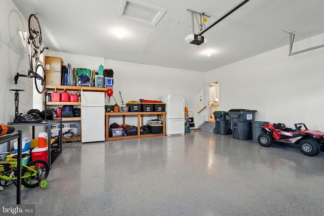 garage featuring freestanding refrigerator and a garage door opener