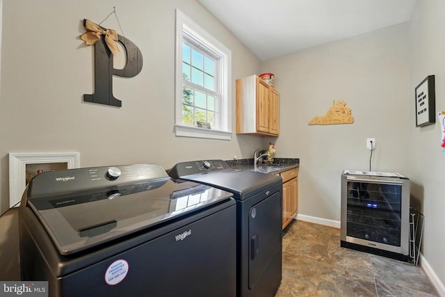 laundry room with wine cooler, independent washer and dryer, cabinet space, baseboards, and stone finish flooring