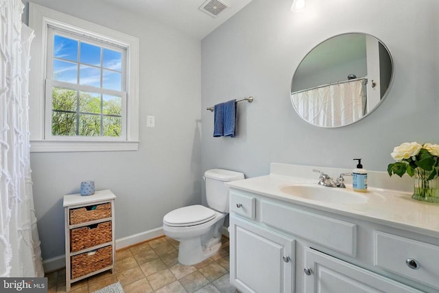 bathroom featuring baseboards, vanity, and toilet