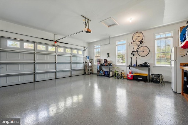 garage featuring a garage door opener and freestanding refrigerator