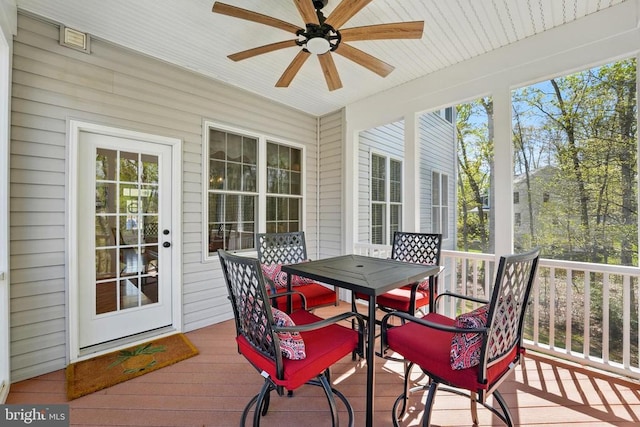 sunroom / solarium featuring ceiling fan and outdoor dining space