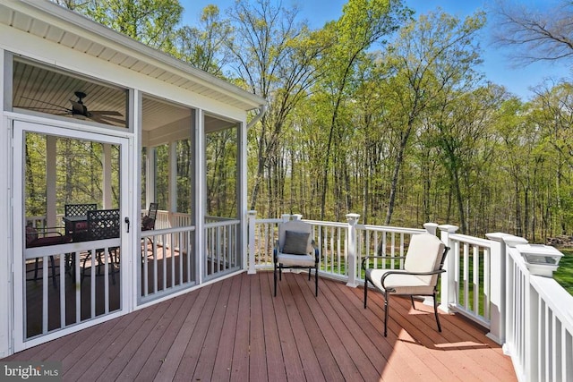 wooden deck featuring a sunroom and ceiling fan