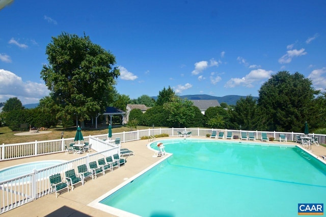 community pool featuring a mountain view, fence, a gazebo, and a patio