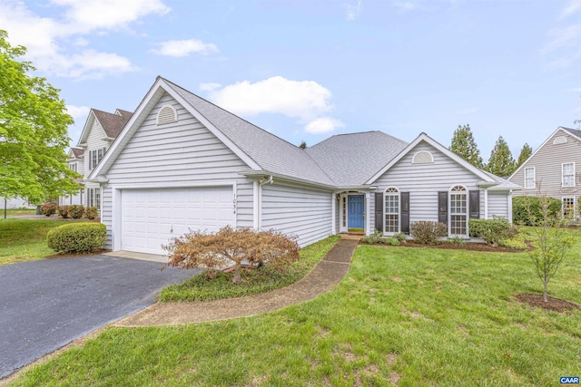 view of front facade featuring roof with shingles, an attached garage, a front lawn, and driveway