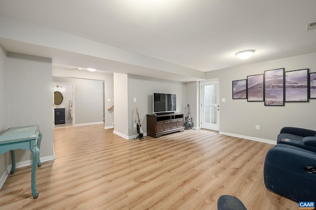 living area featuring baseboards, visible vents, and light wood-style floors