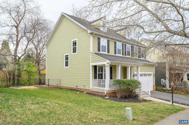 view of front of property with covered porch, a shingled roof, a front lawn, and driveway