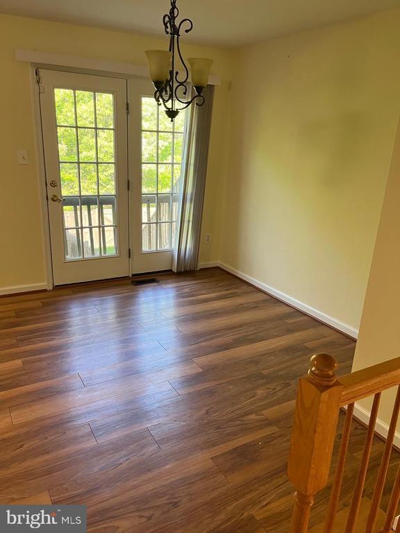 9808 Bartley Ct, Fredericksburg, VA 22408 - unfurnished dining area with a chandelier, baseboards, and dark wood-type flooring