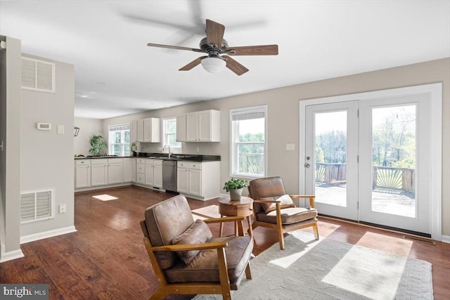 sitting room featuring dark wood-style flooring, a ceiling fan, and baseboards