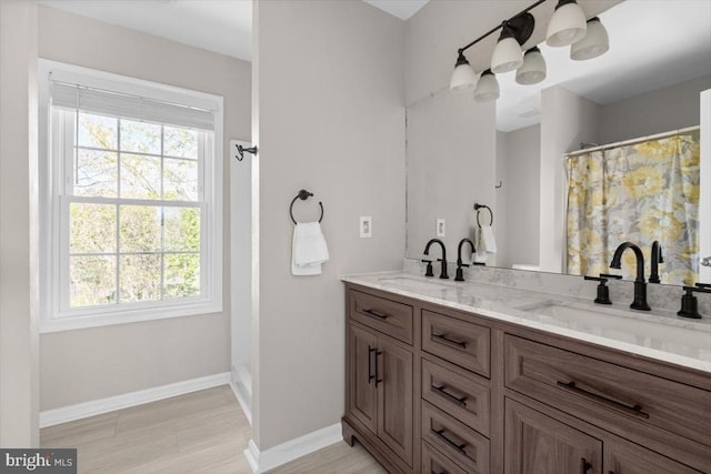 full bathroom with plenty of natural light, baseboards, double vanity, and a shower with shower curtain