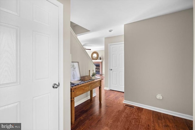 hallway featuring dark wood-style floors and baseboards