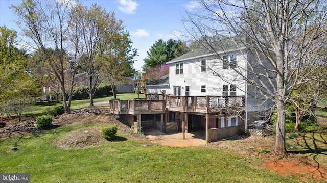 rear view of house with a wooden deck and a lawn