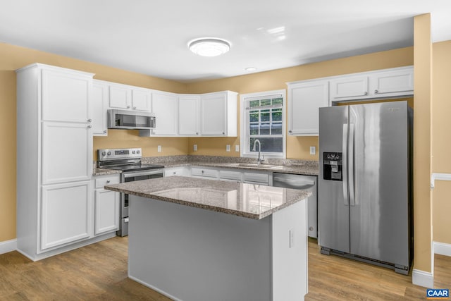 3615 Doctors Xing, Charlottesville, VA 22911 - kitchen with stainless steel appliances, wood finished floors, white cabinets, a kitchen island, and light stone countertops