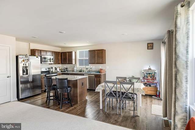 2612 High Pt, Culpeper, VA 22701 - kitchen with stainless steel appliances, a center island, a breakfast bar, dark wood-style flooring, and tasteful backsplash