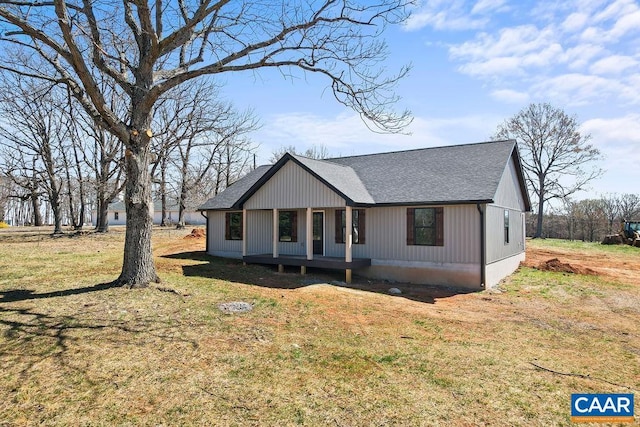 view of front facade with a front yard and roof with shingles