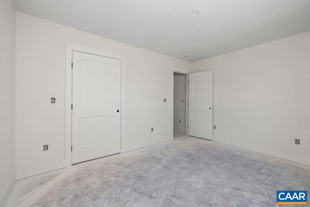 unfurnished bedroom featuring baseboards and unfinished concrete floors