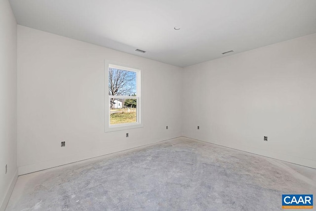 spare room with unfinished concrete flooring, baseboards, and visible vents