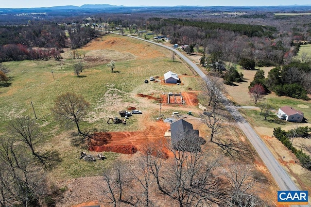 birds eye view of property featuring a rural view and a wooded view