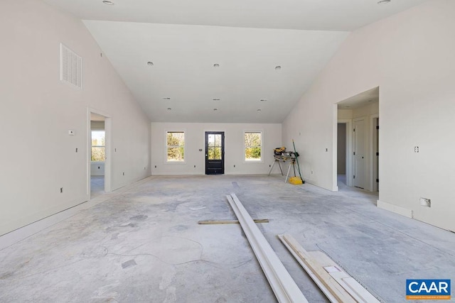 unfurnished living room with baseboards, high vaulted ceiling, a healthy amount of sunlight, and visible vents
