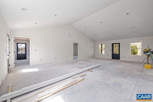 unfurnished living room with visible vents and high vaulted ceiling