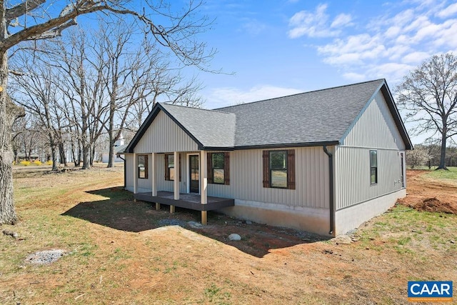 view of front facade featuring roof with shingles and a front yard