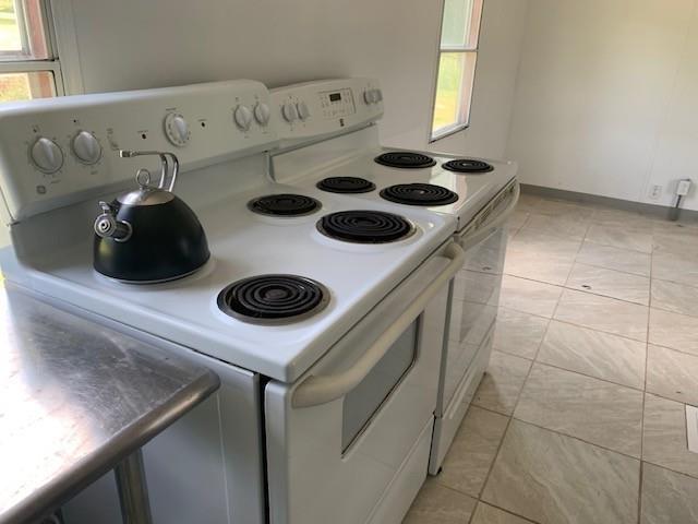 303 Myers-Moon Rd, Monterey, VA 24465 - kitchen with white electric range oven, plenty of natural light, and light tile patterned floors