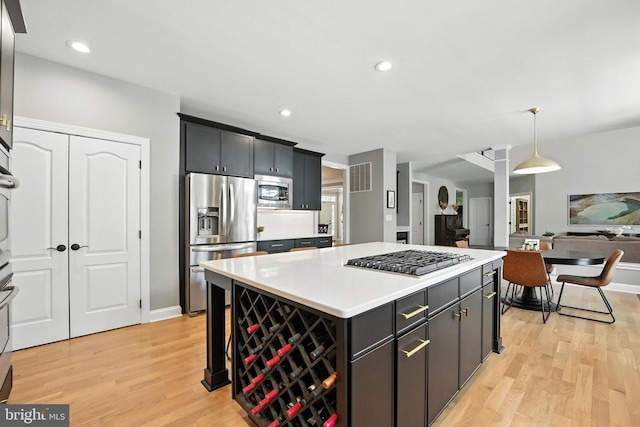 11220 Chivalry Chase Ln, Spotsylvania, VA 22551 - kitchen with appliances with stainless steel finishes, light wood-type flooring, a kitchen island, light countertops, and decorative light fixtures