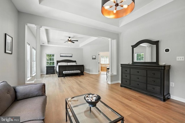 11220 Chivalry Chase Ln, Spotsylvania, VA 22551 - bedroom with a tray ceiling, decorative columns, light wood-style floors, and multiple windows