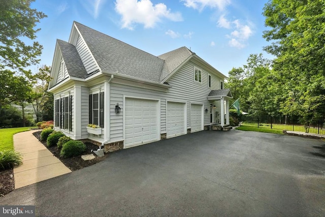 11220 Chivalry Chase Ln, Spotsylvania, VA 22551 - view of property exterior featuring an attached garage, a shingled roof, and asphalt driveway