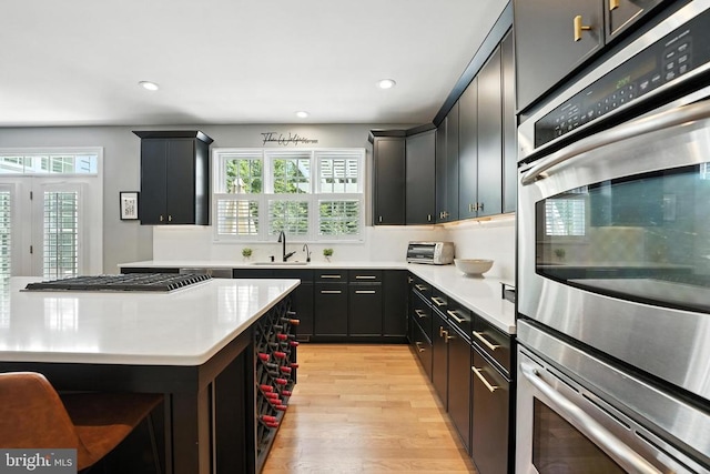 11220 Chivalry Chase Ln, Spotsylvania, VA 22551 - kitchen featuring appliances with stainless steel finishes, light wood-type flooring, light countertops, recessed lighting, and dark cabinets