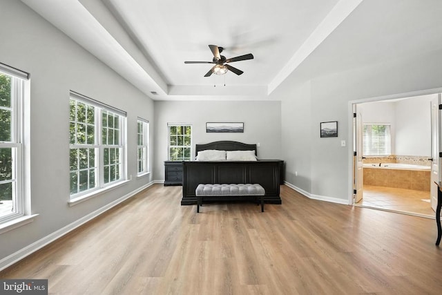 11220 Chivalry Chase Ln, Spotsylvania, VA 22551 - bedroom featuring a tray ceiling, light wood-type flooring, multiple windows, and ensuite bathroom