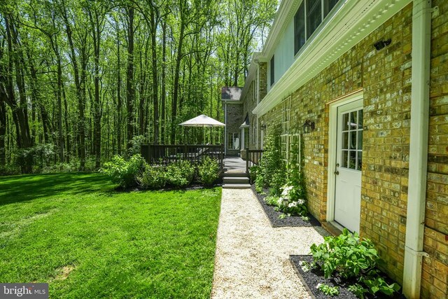  - view of green lawn featuring a wooden deck