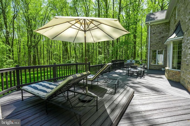  - wooden deck with outdoor dining area and a forest view