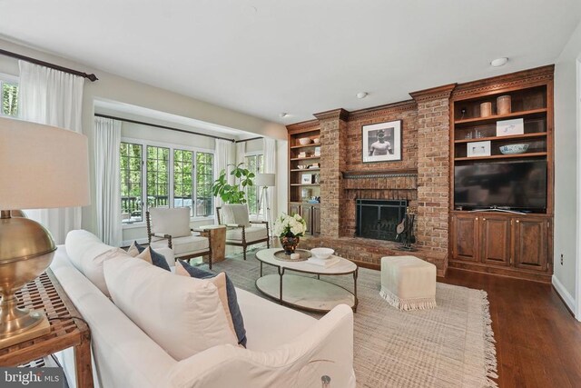  - living room featuring dark wood-style flooring, built in shelves, a brick fireplace, and baseboards