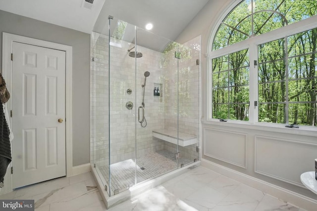  - bathroom featuring marble look tile flooring, a shower stall, and baseboards