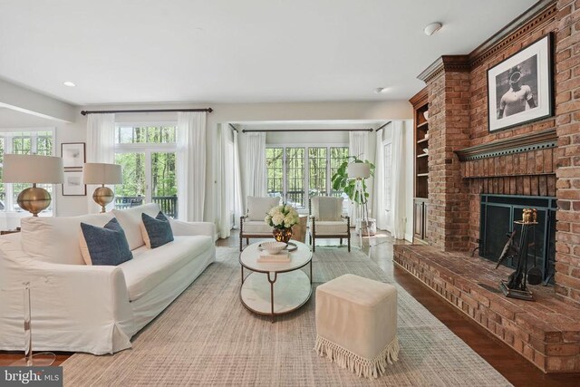  - living room with wood finished floors, a brick fireplace, and recessed lighting