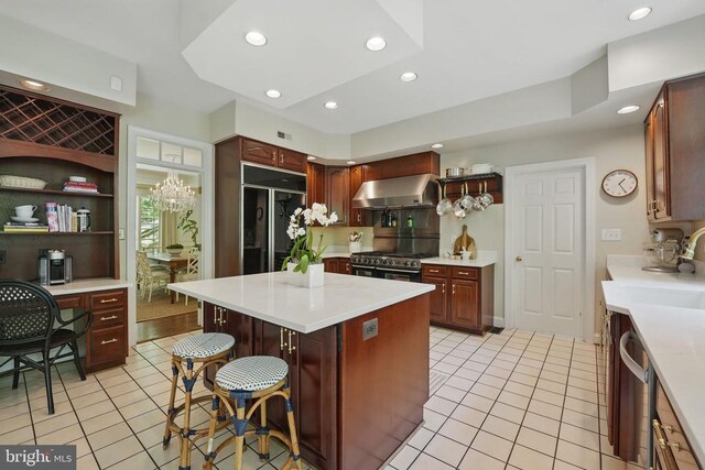  - kitchen with ventilation hood, premium appliances, light tile patterned flooring, a kitchen bar, and recessed lighting