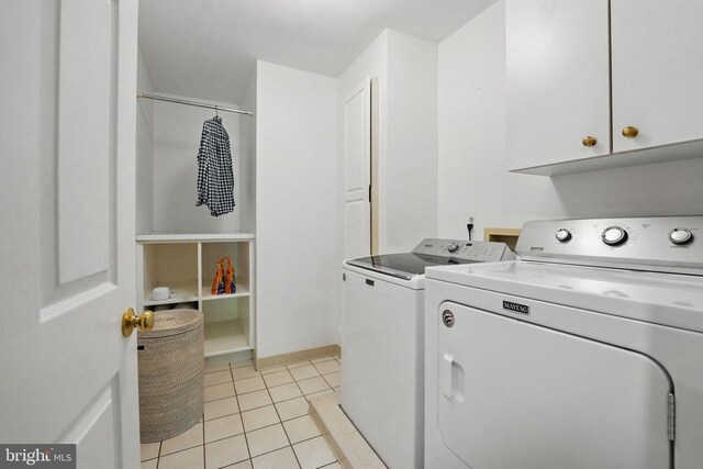  - laundry area featuring cabinet space, washer and clothes dryer, and light tile patterned flooring