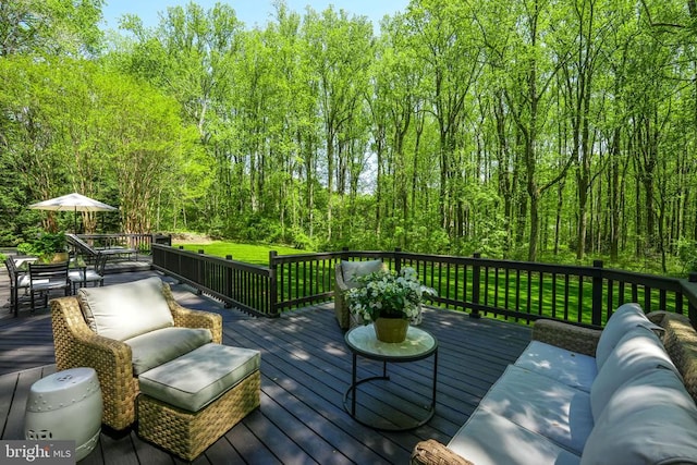 - deck featuring outdoor dining area, a lawn, an outdoor hangout area, and a view of trees