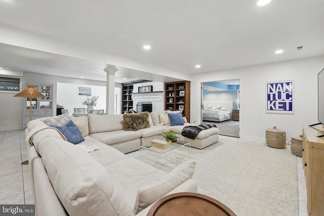  - living area with recessed lighting, a large fireplace, light tile patterned floors, baseboards, and decorative columns