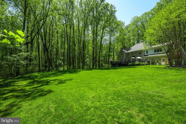  - view of grassy yard with a wooden deck