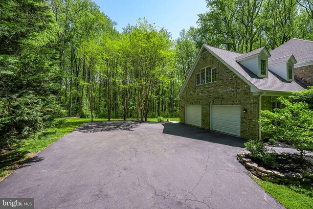  - view of home's exterior featuring asphalt driveway, a garage, and a shingled roof