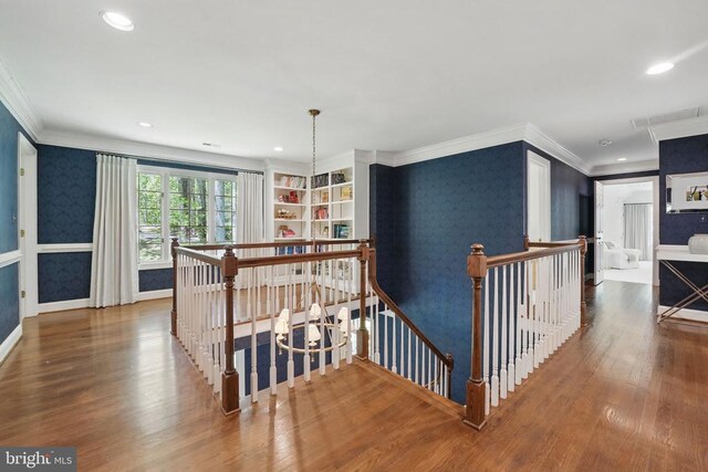  - hallway with an upstairs landing, wallpapered walls, ornamental molding, wood finished floors, and recessed lighting