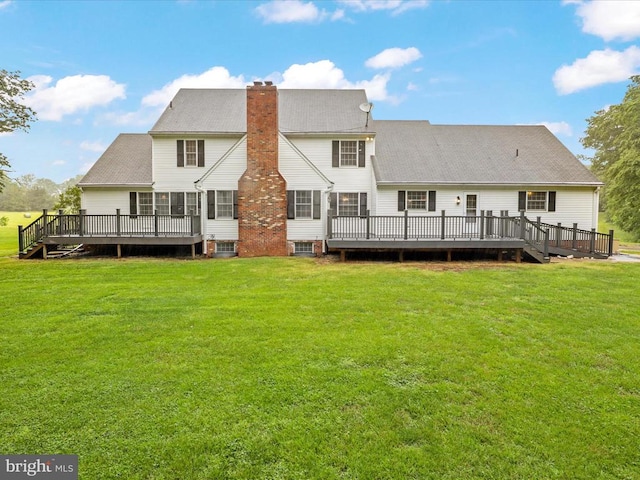  - rear view of house featuring a deck, a chimney, a yard, and roof with shingles