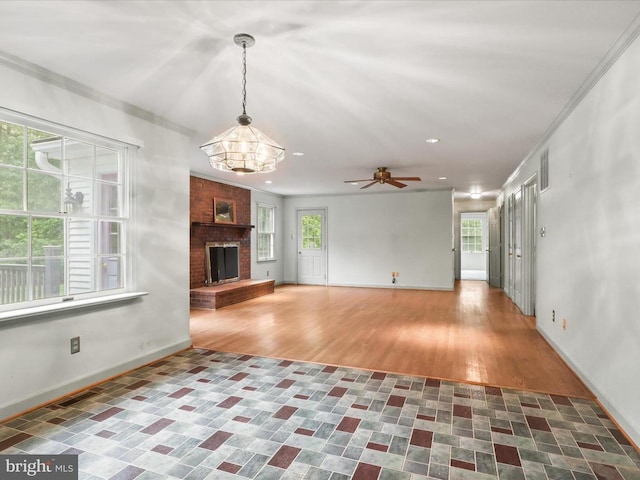  - unfurnished living room with a brick fireplace, recessed lighting, a chandelier, a ceiling fan, and ornamental molding