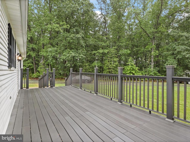  - wooden deck with a yard and view of wooded area
