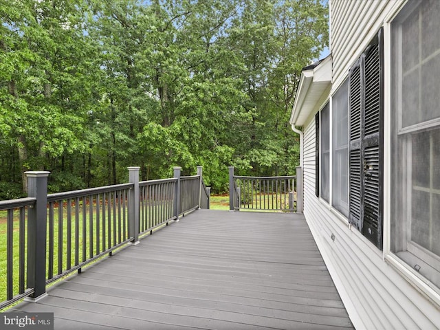  - wooden deck with view of scattered trees and a lawn