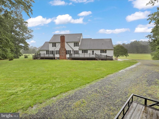  - rear view of property featuring a wooden deck, a yard, and a chimney