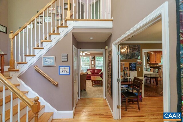 895 Jefferson Dr, Palmyra, VA 22963 - entryway featuring wood finished floors, a towering ceiling, baseboards, stairs, and crown molding