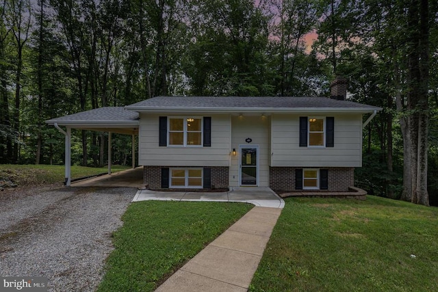 6217 Oak Grove Dr, Fredericksburg, VA 22407 - bi-level home with driveway, a chimney, an attached carport, a front yard, and brick siding