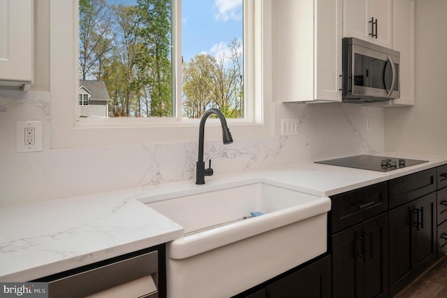 112 Edgehill Dr, Locust Grove, VA 22508 - kitchen featuring stainless steel microwave, black electric cooktop, white cabinets, decorative backsplash, and dark cabinets
